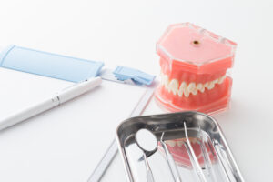 歯列矯正のカウンセリングのイメージ（ペン,問診票,派の模型）